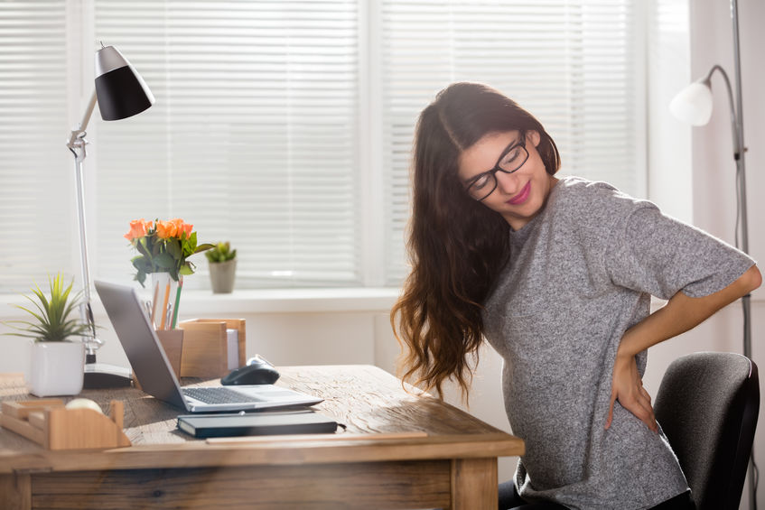 woman with back pain sitting at desk